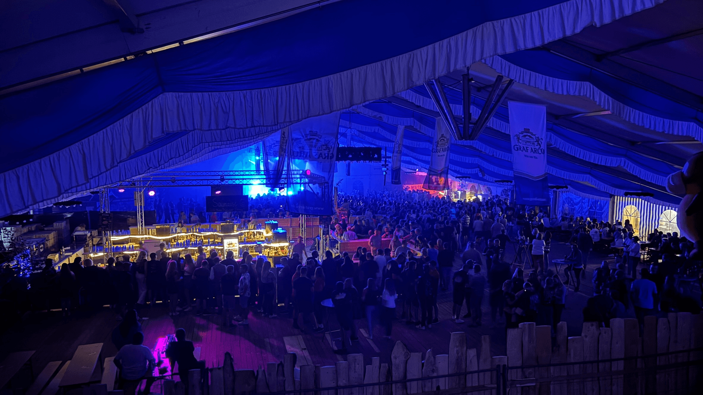 Blick über das nächtliche Festzelt bei „Rock am Saugoan“ mit Band auf der Bühne und tanzenden Gästen