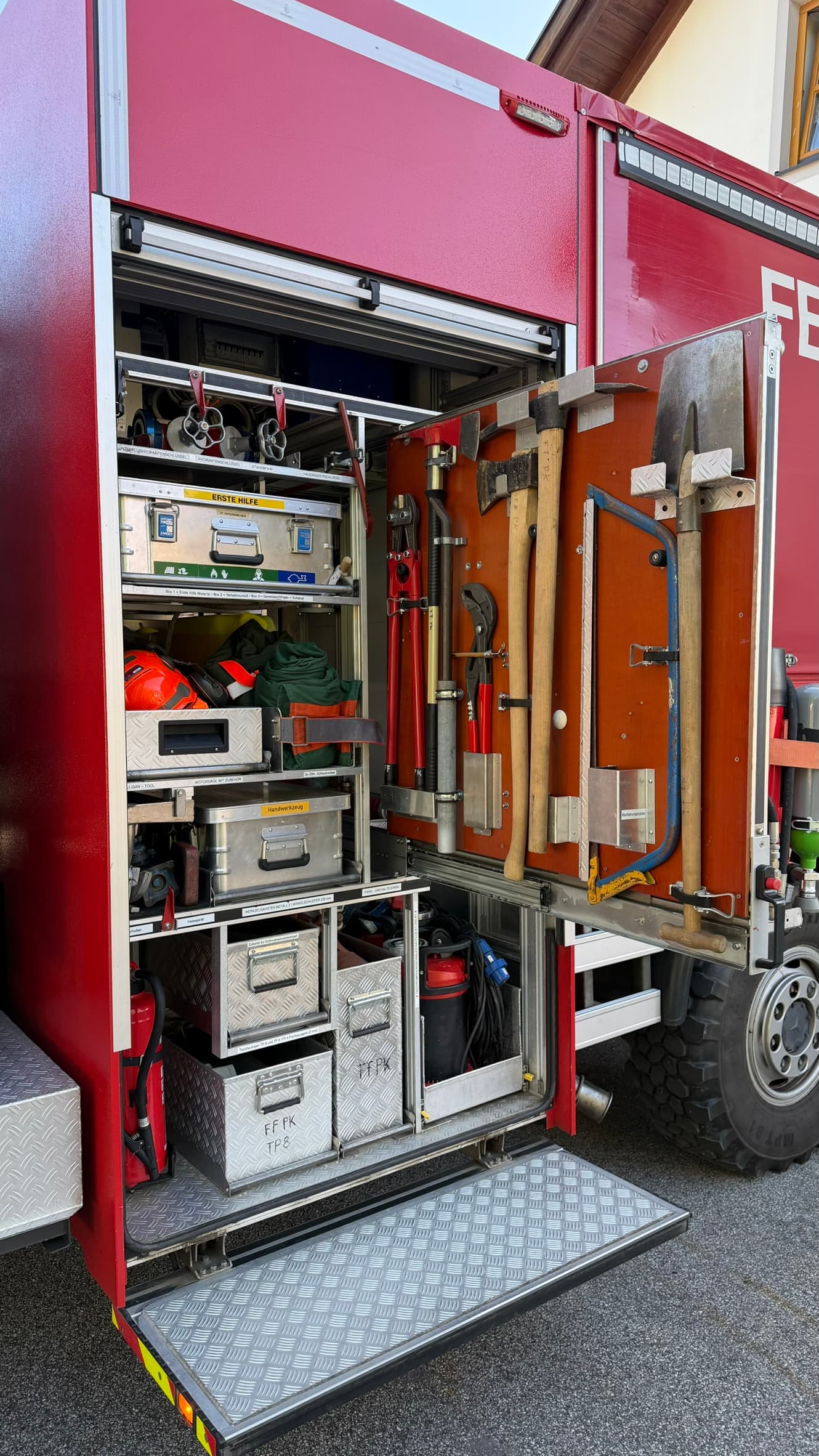 Geöffneter Gerätekoffer links mit Erste-Hilfe-Box, Werkzeug und ausgeschwenkter Werkzeug-Schiebewand