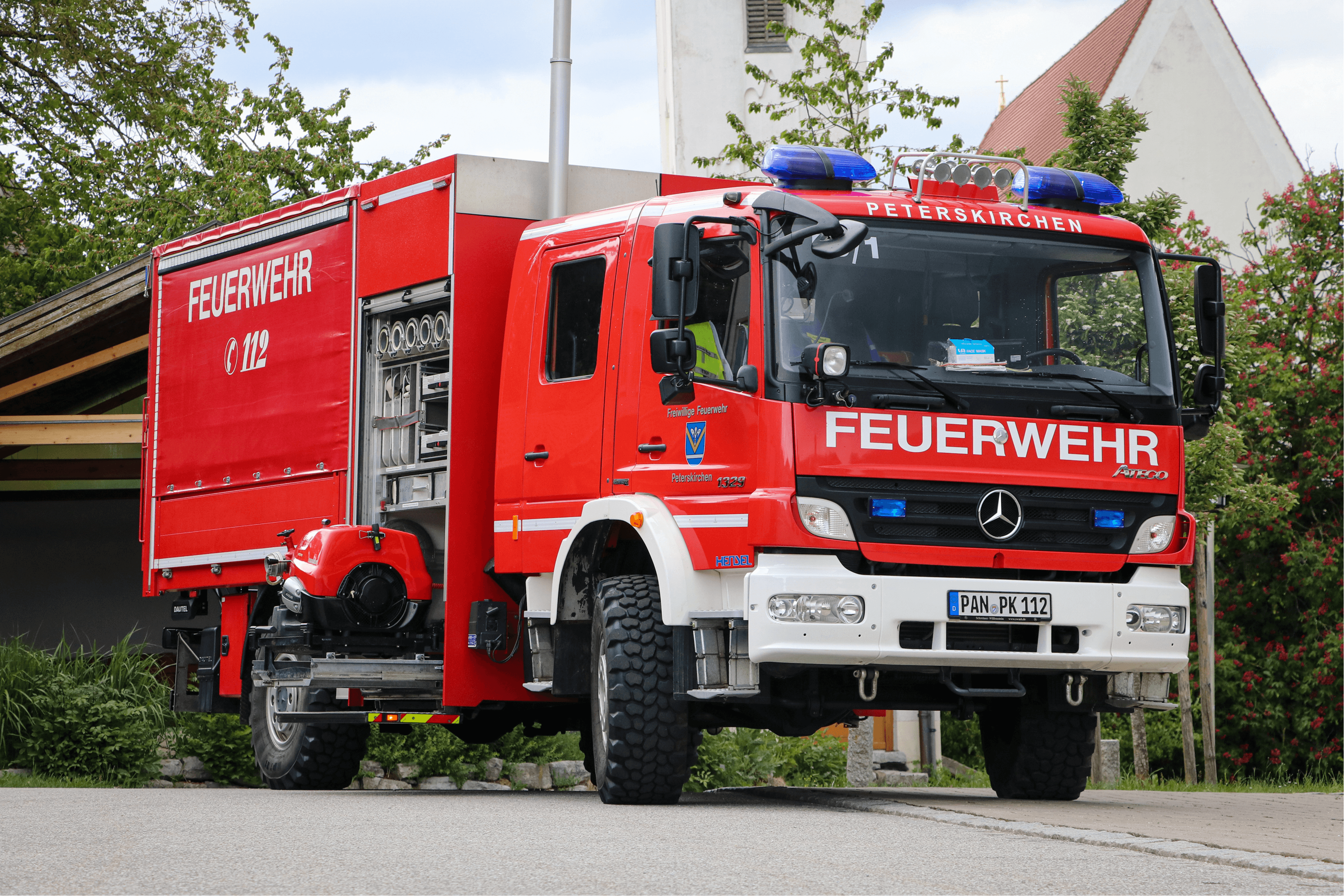 Gerätewagen von schräg vorne in Untersicht vor der Kirche Peterskirchen
